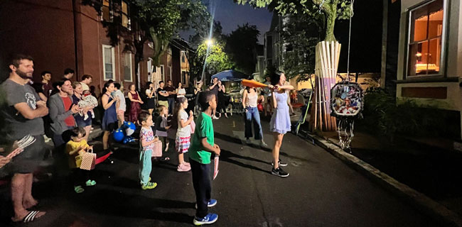 Crowd gathered at night for block party on Fairmont Avenue, Cambridge, summer 2023.