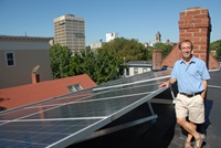 Man standing next to solar array in Cambridge