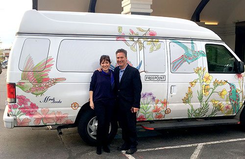 Miriam E. Bucheli (left) with Cambridge Arts Executive Director Jason Weeks pose with the van from Cambridge’s Freepoint Hotel decorated with her art.