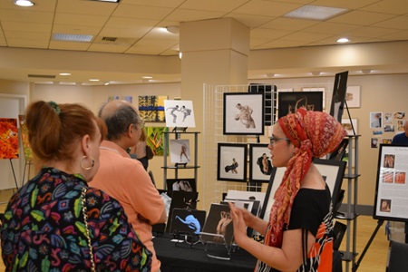 A vendor shows their work to viewers during Cambridge Open Studios.