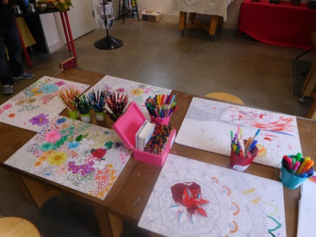 A table with partially colored in coloring pages by Mireli Books