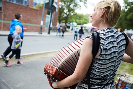 An accordion player plays to people passing by