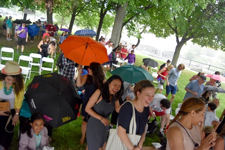 The crowd heads under the Dance Stage tent during a brief rain shower at the 2018 River Festival.