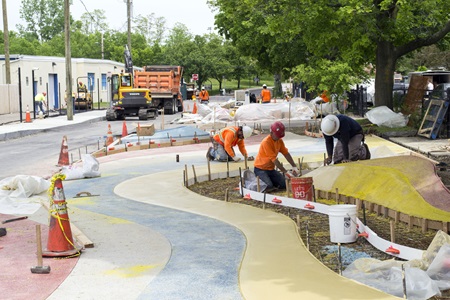 Workers laying down colorful concrete