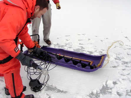 Preparing the multiprobe for measuring temperature and dissolved oxygen levels in the water beneath the ice.