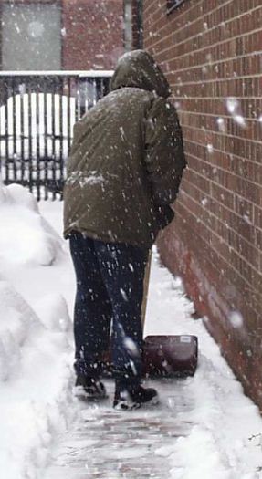 Person shoveling a sidewalk