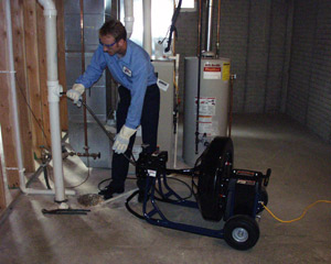 Tech cleaning pipe in basement