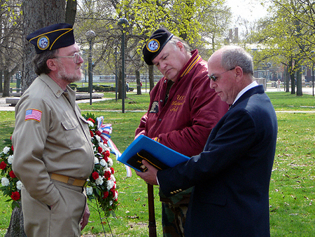 Master of Ceremonies James Grey, President of the Cambridge Veterans' Organization, looks over his notes.