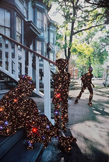 In front of a row of houses, the shapes of children playing have been replaced by images of the cosmos