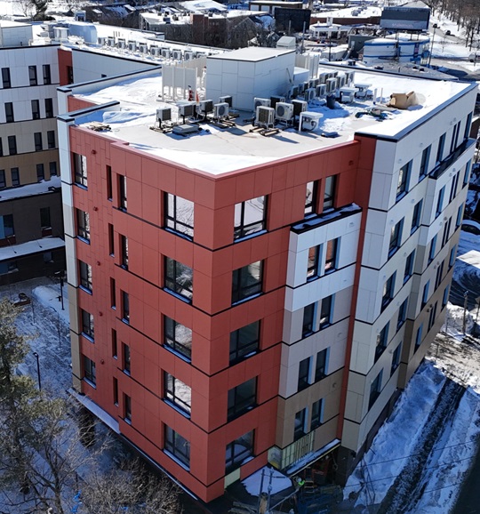 Aerial image of 52 New Street, which is a six-story building with a smooth modern exterior and red siding
