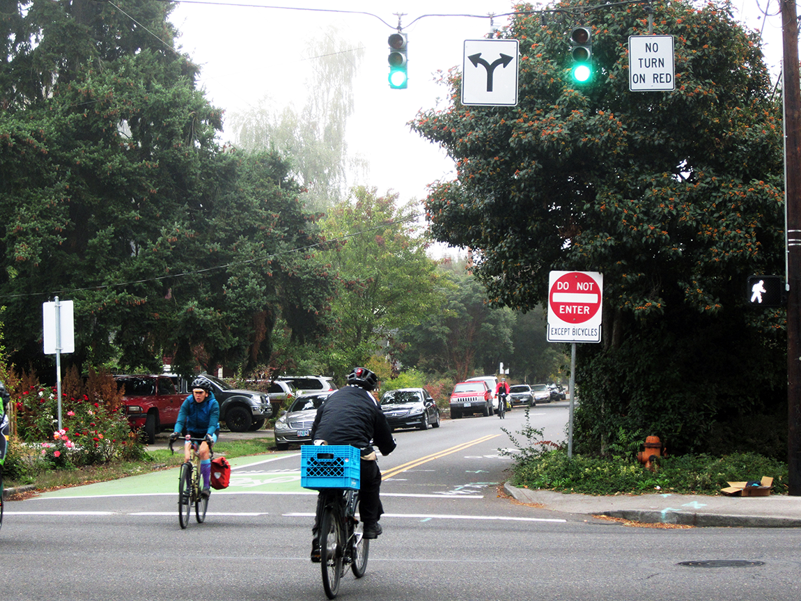 People biking on a street with a contraflow bike lane