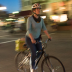 Smiling woman riding a bike at night
