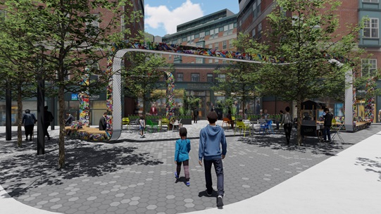 Photo-rendering of the proposed primary concept design for Carl Barron Plaza. The rendering shows the plaza at Massachusetts Avenue and River Street, facing the Holmes Building store fronts for Cambridge Savings Bank and Amazon. A ribbon-like metal sculptural structure is the center-piece of a renewed public space at Carl Barron Plaza. Additional features include more street tree plantings, new pavement surfaces, and spaces to program public events.