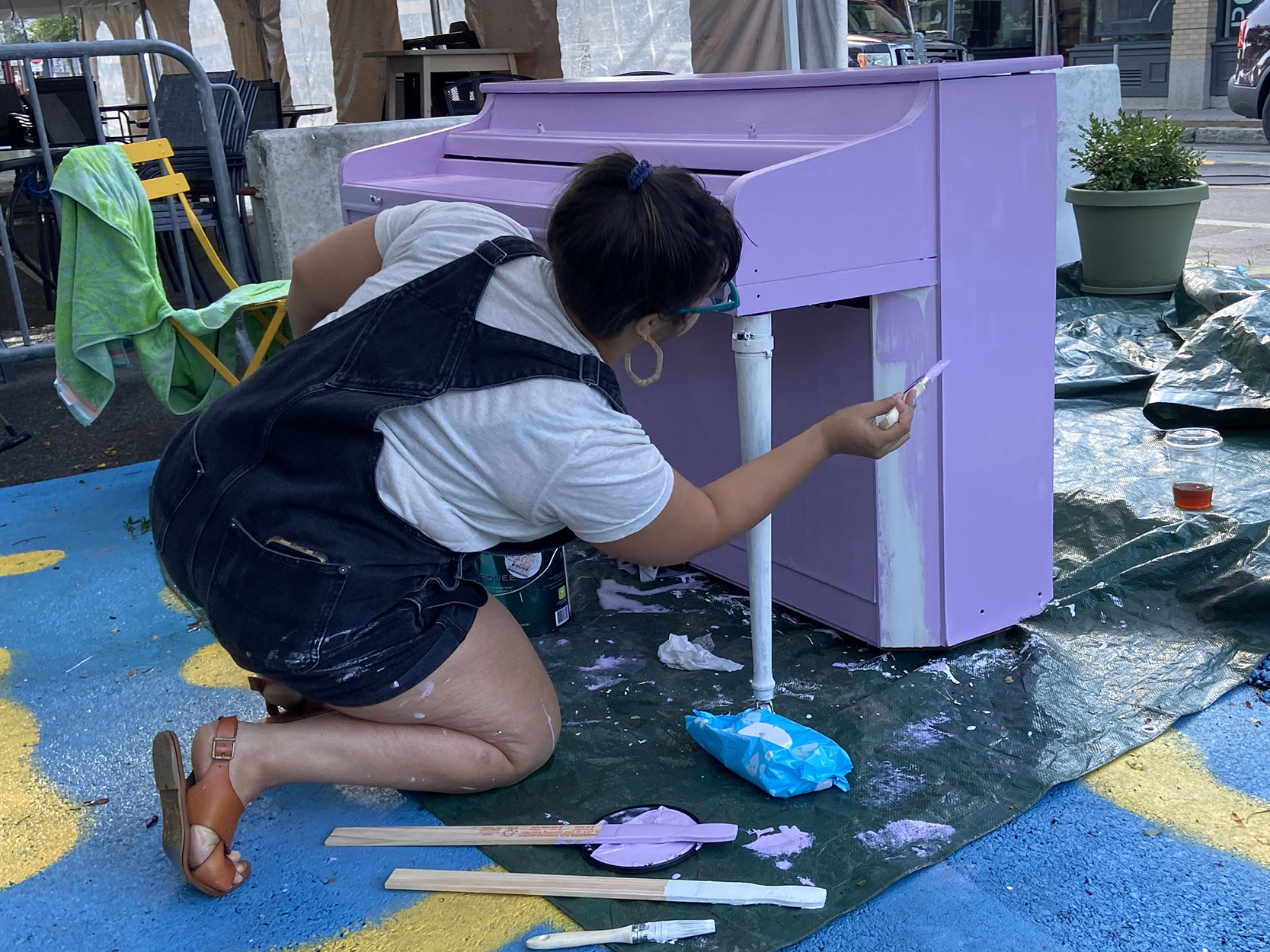 Someone painting a public piano