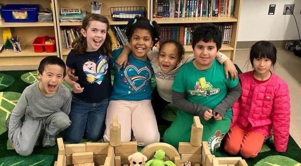 Children in an afterschool program pose with a structure they built. 