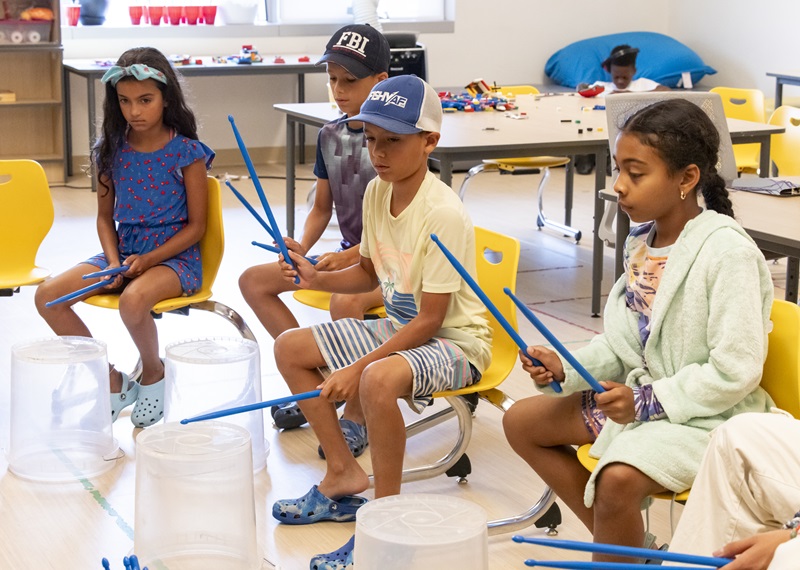 Children take a drumming lesson during a Community Schools program