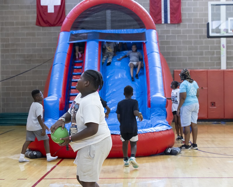 middle schoolers play sports and slide down a blow up slide at a CYP celebration.