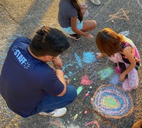 DHSP staff play use chalk with a child
