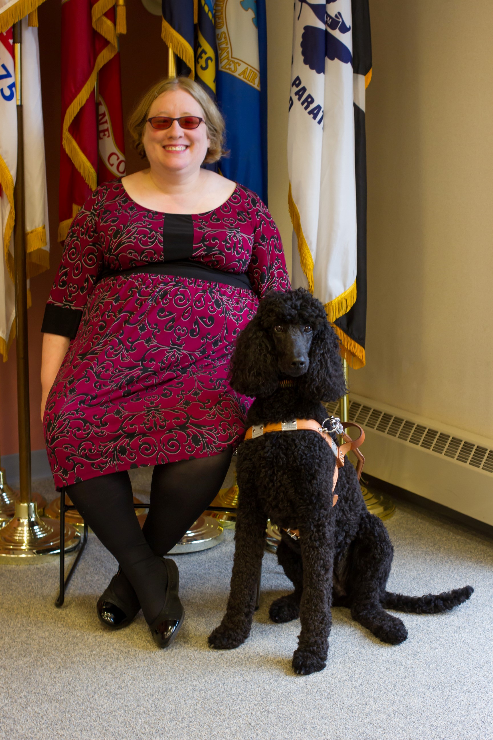 Rachel Tanenhaus seated next to her guide dog