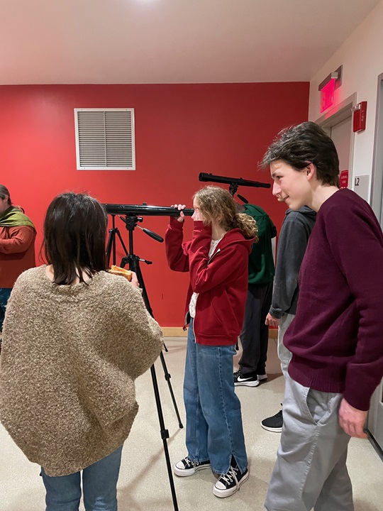 young people learn how to use a telescope