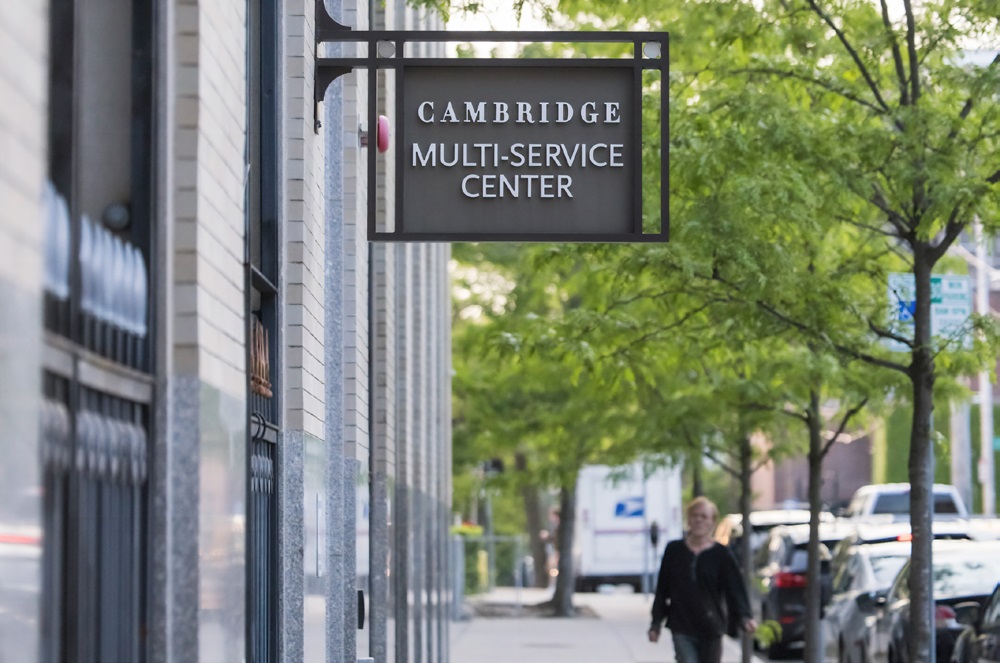 A sign extending from a building that reads "Cambridge Multi-Service Center."