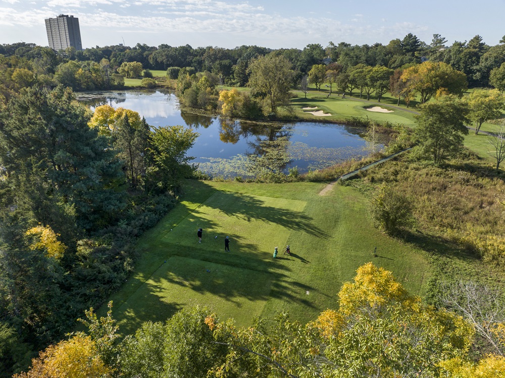 An aerial view of golfers on the course with Fresh Pond in the middle.