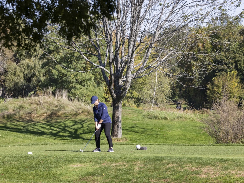 A man preparing to hit a drive at a teeing area on the golf course.