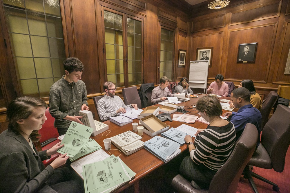 The meeting room with people seated at tables talking about participatory budgeting.
