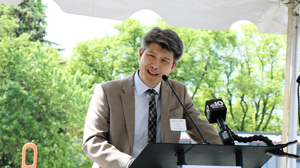 City Manager Yi-An Huang stands at a podium, delivering a speech to an audience.