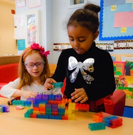 two preschool girls build legos