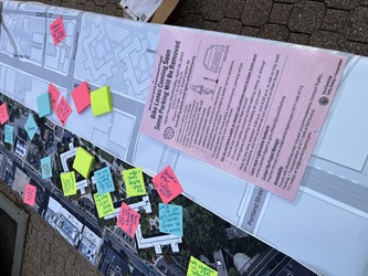 A map with sticky notes about current conditions on Main Street. On top of the map, a laminated flyer reads "Bike Lanes Coming Soon, Some Parking will be Removed"