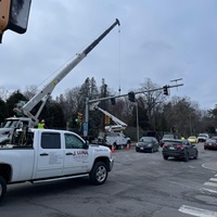 White arm truck installing signal at traffic light