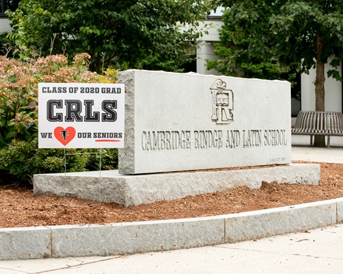 A sign congratulating the 2020 CRLS graduates next to a large stone that is engraved with "Cambridge Rindge and Latin School".