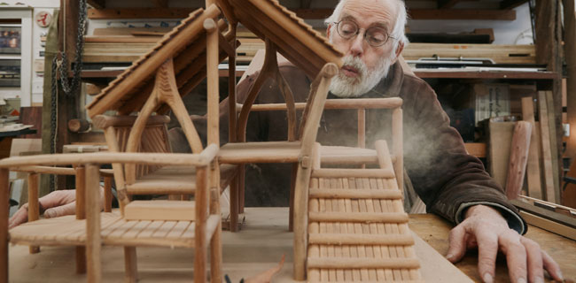 Mitch Ryerson with a playground model in his studio. ("Dust" by Mei Tao, 2024.)