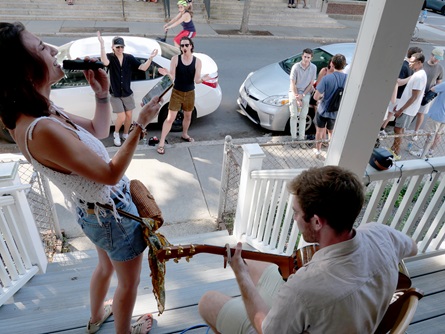 An audience member sings with Tom Dillon (right) for his live karaoke on Pearl Street during the 2026 Cambridge Porchfest.