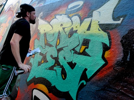 Spray painting in Graffiti Alley during the 2026 Cambridge Porchfest.