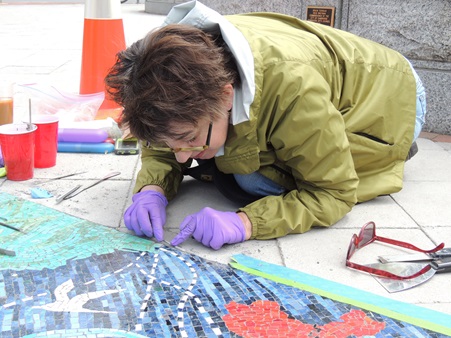 Director of Art Conservation Rika Smith McNally installs new grout during the repair of the mosaic by artist Heidi Whitman entitled 