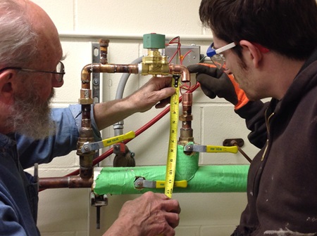 Conservation Technician Rory Beerits works with Engineer George Bossarte to make mechanical repairs to 