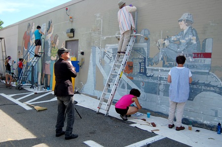 Mural artist Bernard LaCasse oversees the mural restoration