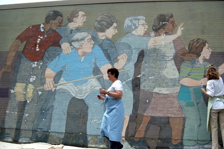 Rika McNally-Smith walks in front of the mural