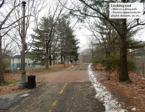 View of the current Linear Park: Paved path between trees and light poles with band of snow of right side.