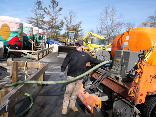 To prepare for snow in March, Department of Public Works crews loaded spray trucks with a brine solution from storage tanks on Sherman Street upon which Monique Aimee painted murals during the summer of 2020.