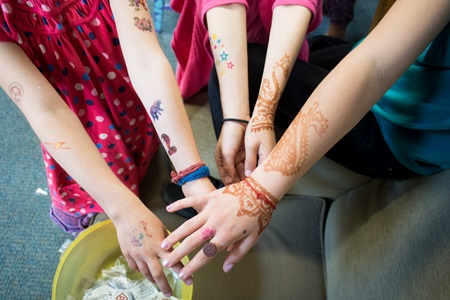 Girls show off their temporary henna designs and temporary tattoos during Cambridge Open Studios.