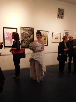An artist modeling a sculptural dress piece at the Cambridge Arts Open Studios reception