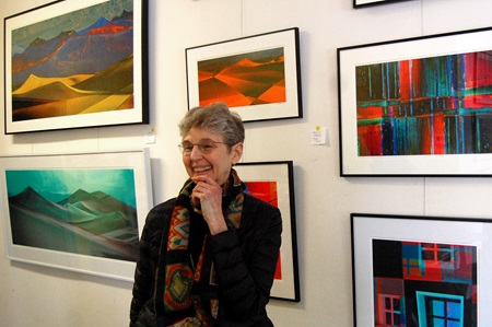 Artist Estelle Disch stands in front of some of her paintings