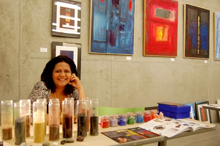 Cambridge Artist Margarette Mattos poses with some of her work