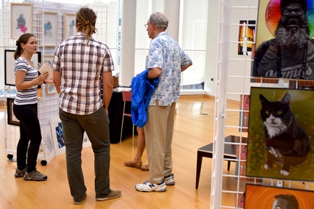 Yuliya Goncharov (left) talks about her art at the Atrium at Harvard Square during the 2018 Cambridge Arts Open Studios.