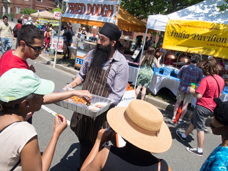 A vendor from India Pavilion, the first Indian restaurant in Cambridge, offers free samples during Cambridge River Festival.