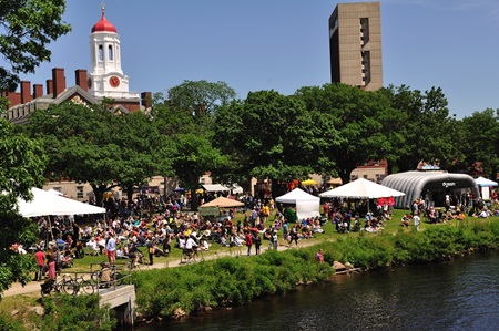 A landscape view from across the river of a bustling Cambridge River Festival.