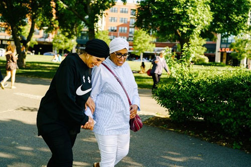 Two people walk in park.